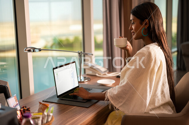 سيدة اعمال عربية خليجية سعودية تستخدم الحاسوب المحمول ، العمل عن بعد ، إنجاز مهام العمل ، مهن ووظائف ، جلسة عمل ، تصفح الإنترنت ، التسويق الإلكتروني ، سياحة وفندقة ، غرفة فندقية