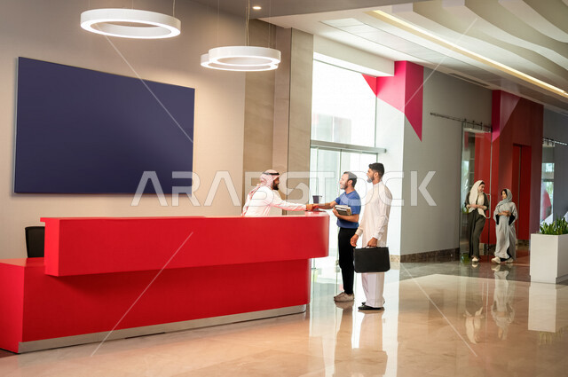 موظفان عربيان سعوديان خليجيان في ردهة الإستقبال في شركه, طالبان عربيان سعوديان خليجيان في مركز الإستقبال في بهو الجامعه, مكتب الإستقبال, مركز إستعلامات, مكتب التسجيل والدخول, استقبال الطلاب, خدمة العملاء, جامعات وكليات اكاديميه متطوره في السعوديه