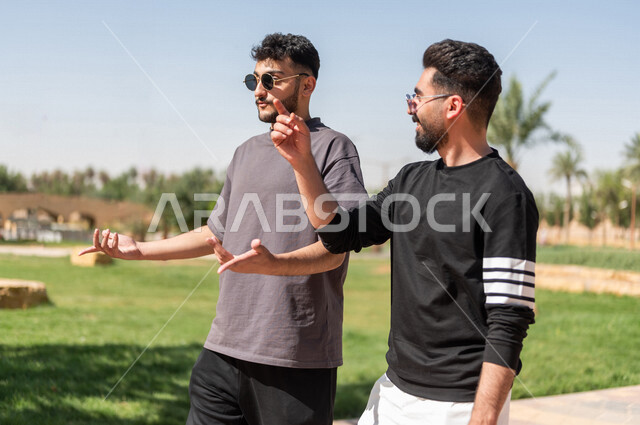 Close-up of two Saudi Arabian Gulf friends practicing morning sports, walking, morning activities, picnics and recreation, chatting and conversations, youth activities, outdoor picnics, recreational trips, exercise, gardens and parks