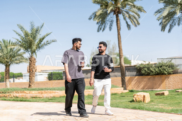 صديقان عربيان خليجيان سعوديان يمارسان الرياضة الصباحية، ممارسة رياضة المشي الهواء الطلق مع احتساء كوب من القهوة، دردشة ومحادثات، نشاطات شبابية، رحلة ترفيهية، طريق ممشى في الحدائق والمنتزهات، نزهه في الهواء الطلق