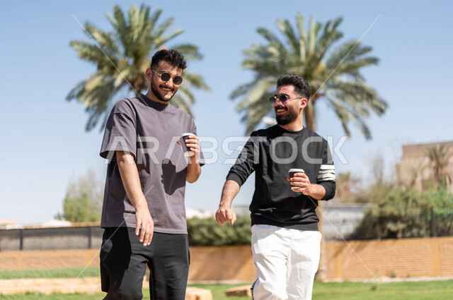 صديقان عربيان خليجيان سعوديان يمارسان الرياضة الصباحية، ممارسة رياضة المشي الهواء الطلق مع احتساء كوب من القهوة، دردشة ومحادثات، نشاطات شبابية، رحلة ترفيهية، طريق ممشى في الحدائق والمنتزهات، نزهه في الهواء الطلق