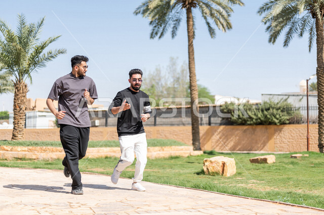 صديقان عربيان خليجيان سعوديان يمارسان رياضة الجري، الصحة واللياقة الجسدية، نشاط بدني في الهواء الطلق، التنزه في الحدائق العامة، تمارين اللياقة البدنية، ممارسة نشاط رياضي، لياقة ورشاقة، طريق ممشى في الحدائق والمنتزهات، نزهه في الهواء الطلق