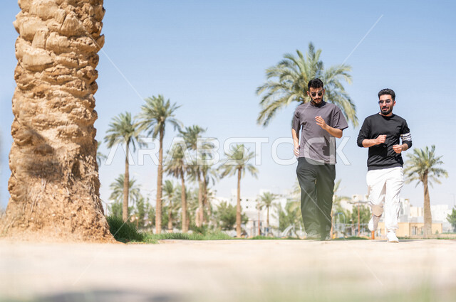 صديقان عربيان خليجيان سعوديان يمارسان رياضة الجري، الصحة واللياقة الجسدية، نشاط بدني في الهواء الطلق، التنزه في الحدائق العامة، تمارين اللياقة البدنية، ممارسة نشاط رياضي، لياقة ورشاقة، طريق ممشى في الحدائق والمنتزهات، نزهه في الهواء الطلق