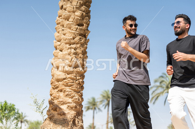 صديقان عربيان خليجيان سعوديان يمارسان رياضة الجري، الصحة واللياقة الجسدية، نشاط بدني في الهواء الطلق، التنزه في الحدائق العامة، تمارين اللياقة البدنية، ممارسة نشاط رياضي، لياقة ورشاقة، طريق ممشى في الحدائق والمنتزهات، نزهه في الهواء الطلق