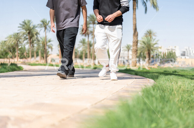 صورة مقربة لصديقان عربيان خليجيان سعوديان يمارسان الرياضة الصباحية، ممارسة رياضة المشي، قضاء اوقات ممتعة في الحدائق العامة، دردشة ومحادثات، نشاط بدني، طريق ممشى في الحدائق والمنتزهات، ممارسة التمارين الرياضية، نزهه في الهواء الطلق