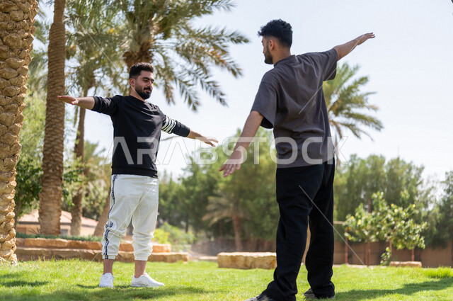 شابان عربيان خليجيان سعوديان يمارسان تمارين التمدد، تمديد عضلات الجسم، ممارسة نشاط رياضي، أنشطة و تمارين رياضية، الرياضة والنشاط البدني، تمارين اللياقة البدنية، أسلوب حياة صحي، لياقة ورشاقة