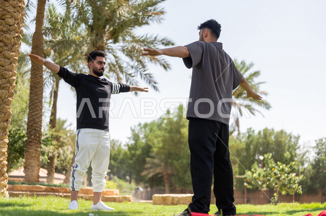 شابان عربيان خليجيان سعوديان يمارسان تمارين التمدد، تمديد عضلات الجسم، ممارسة نشاط رياضي، أنشطة و تمارين رياضية، الرياضة والنشاط البدني، تمارين اللياقة البدنية، أسلوب حياة صحي، لياقة ورشاقة