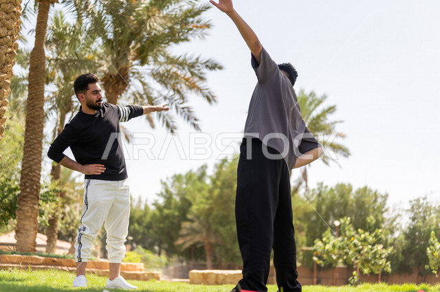 شابان عربيان خليجيان سعوديان يمارسان تمارين التمدد، تمديد عضلات الجسم، ممارسة نشاط رياضي، أنشطة و تمارين رياضية، الرياضة والنشاط البدني، تمارين اللياقة البدنية، أسلوب حياة صحي، لياقة ورشاقة