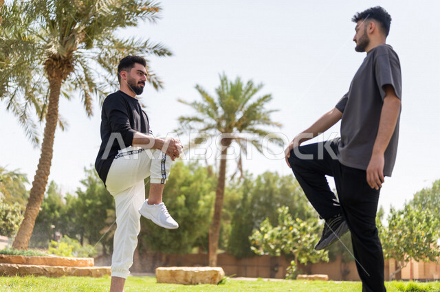 شابان عربيان خليجيان سعوديان يمارسان تمارين التمدد، تمديد عضلات الجسم، ممارسة نشاط رياضي، أنشطة و تمارين رياضية، الرياضة والنشاط البدني، تمارين اللياقة البدنية، أسلوب حياة صحي، لياقة ورشاقة