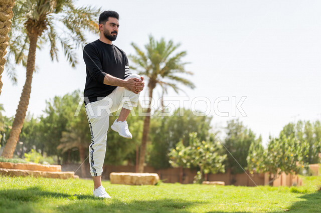شاب عربي خليجي سعودي يمارس تمارين التمدد، تمديد عضلات الجسم، ممارسة نشاط رياضي، أنشطة و تمارين رياضية، الرياضة والنشاط البدني، تمارين اللياقة البدنية، أسلوب حياة صحي، لياقة ورشاقة