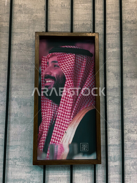 صورة معلقة على الجدار لصاحب السمو الملكي ولي العهد الأمير محمد بن سلمان، إيماءات وجه مبتسمة، برواز صور