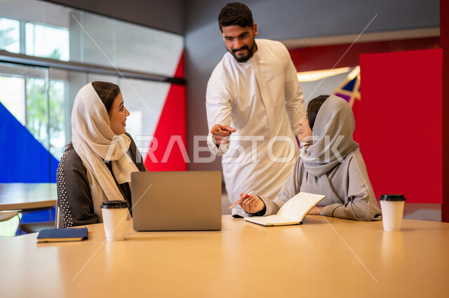 A close-up photo of a group of Arab Saudi Gulf university students in the university cafe, cooperation and sharing, working on the computer, advanced academic universities, Saudi Arab Gulf employees in the company cafe, conversations and discussions, busi