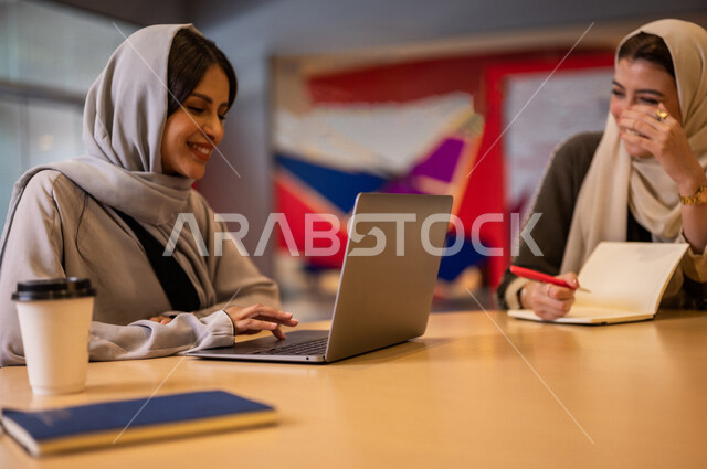 A close-up photo of two Saudi Arabian Gulf students in the university cafe, cooperation and participation, working on the computer, advanced academic colleges and universities, two Saudi Arabian Gulf employees in the company cafe, conversations and discus