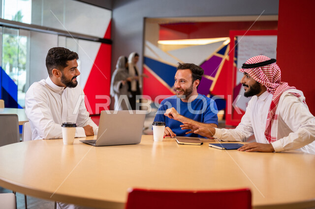 A close-up photo of a group of Arab Saudi Gulf university students in the university cafe, cooperation and sharing, working on the computer, advanced academic universities, Saudi Arab Gulf employees in the company cafe, conversations and discussions, busi