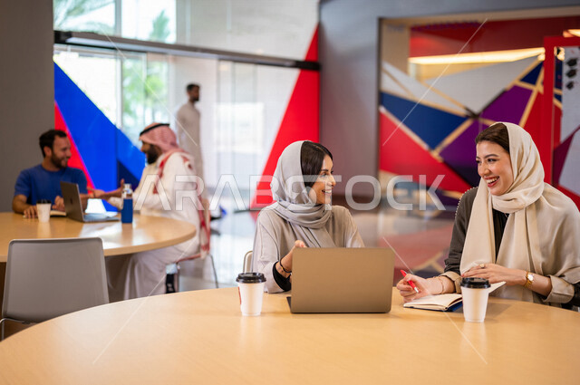 A close-up photo of a group of Arab Saudi Gulf university students in the university cafe, cooperation and sharing, working on the computer, advanced academic universities, Saudi Arab Gulf employees in the company cafe, conversations and discussions, busi