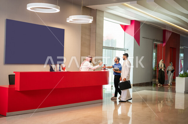 موظفان عربيان سعوديان خليجيان في ردهة الإستقبال في شركه, طالبان عربيان سعوديان خليجيان في مركز الإستقبال في بهو الجامعه, مكتب الإستقبال, مركز إستعلامات, مكتب التسجيل والدخول, استقبال الطلاب, خدمة العملاء, جامعات وكليات اكاديميه متطوره في السعوديه