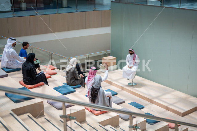 صوره من الخلف لطلاب جامعيون عرب سعوديون خليجيون في قاعة المحاضرات في الجامعه, الإستماع الى المحاضره, ورش عمل, دورات تدريبيه, جامعات أكاديميه متطوره, موظفون عرب سعوديون خليجيون في شركه, إجتماع عمل, الحوارات والنقاشات, فريق عمل سعودي