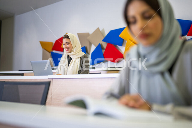 A close-up picture of a Saudi Arabian Gulf student in the lecture hall at the university, university students, taking notes, listening to the lecture, workshops, training courses, lessons and lectures, quality education, academic universities in Saudi Ara