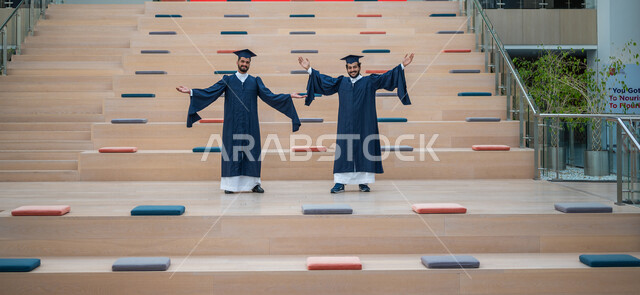 Two Saudi Arabian Gulf students wearing the abaya and graduation cap, graduation celebration from the university, graduation ceremony, graduation dress, the campus building, gestures indicating happiness with excellence and success, academic universities 