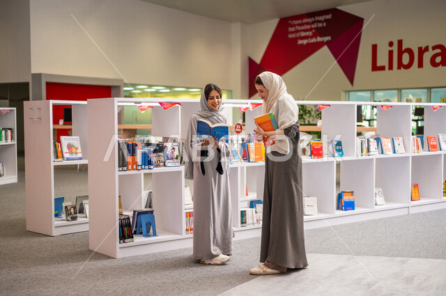 إمرأتان عربيتان سعوديتان خليجيتان في بيئة جامعيه تعليمية متطورة, طلاب جامعه, قراءة الكتب في مكتبة الجامعه، التعليم الذاتي, مفهوم القراءه والثقافه، جودة التعليم, جامعات اكاديميه في المملكه العربيه السعوديه, برامج أكاديميه, كليات و جامعات متطوره