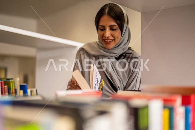 صورة مقربة لإمرأة عربية سعوديه خليجيه في بيئة جامعيه تعليمية متطورة، طالبه جامعيه, قراءة الكتب في مكتبة الجامعه، التعليم الذاتي, مفهوم القراءه والثقافه، جودة التعليم, جامعات اكاديميه في المملكه العربيه السعوديه, برامج أكاديميه, كليات و جامعات متطوره