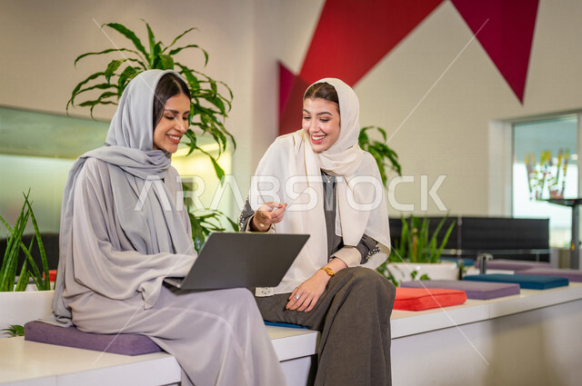 صوره مقربه لإمرأتان عربيتان سعوديتان خليجيتان, استخدام جهاز الحاسوب المحمول, طالبات جامعيات، أبحاث ودراسات علميه, حوارات ونقاشات، متابعة الأعمال، جودة التعليم، صداقة عمل، تصفح الإنترنت، جامعات أكاديمه متطوره في السعوديه 