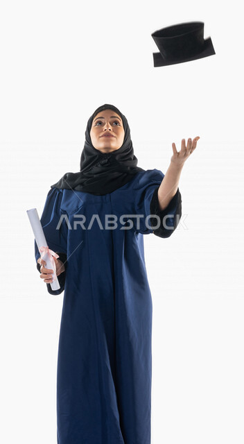 بورتريه لطالبة عربية سعودية خليجية ترتدي العباءه وقبعة التخرج, تمسك بيدها شهادة النجاح و التفوق, ترمي القبعه عاليا, اللباس الأكاديمي, خريجه جامعيه, حفل تخرج, نتائج الاختبارات, تلميذه متفوقه, أجواء احتفاليه بالنجاح, التعليم في المملكة العربية السعودية , خل