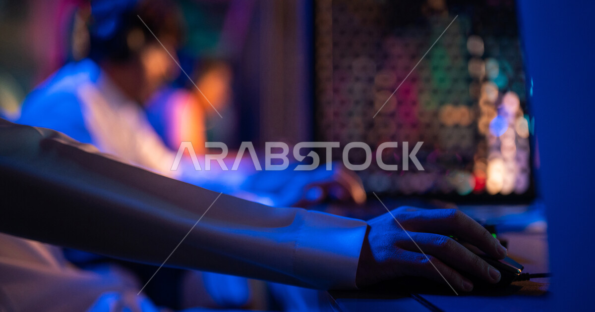 Closeup of the hands of a Saudi Arabian Gulf youth in an electronic games store, playing