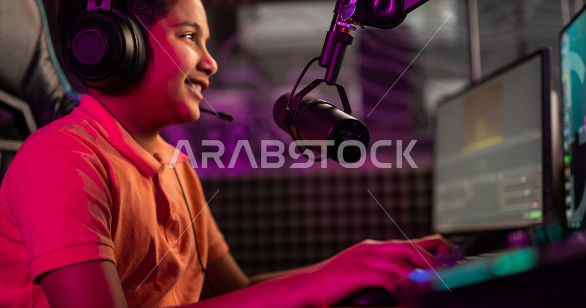 Closeup of a Saudi Arabian Gulf boy in an electronic game store, wearing a headset, a
