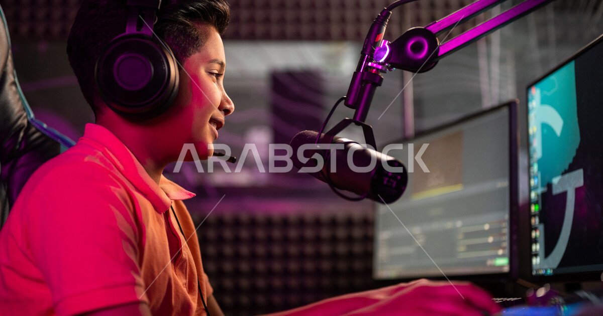 Closeup of a Saudi Arabian Gulf boy in an electronic game store, wearing a headset, a