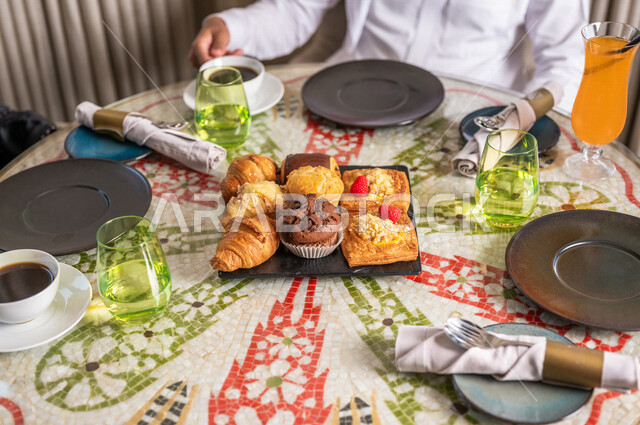 صورة مقربة لأشخاص على مائدة طعام ، المشروبات الساخنة ، أصناف متعددة من المعجنات والمخبوزات الشهية ، الكرم والضيافة ، التحلاية ، مطاعم السعودية