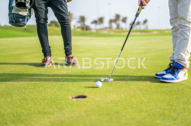 A close-up of two Saudi Arabian Gulf men, playing golf on large green areas, sports activities in Saudi Arabia, golf, summer Olympic sports, recreational activities, enjoying playing, identifying and shooting the target