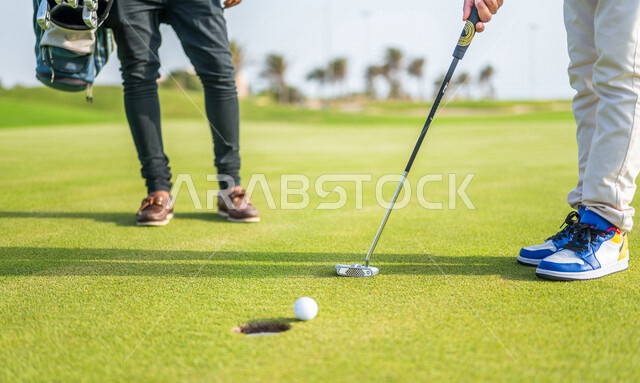 A close-up of two Saudi Arabian Gulf men, playing golf on large green areas, sports activities in Saudi Arabia, golf, summer Olympic sports, recreational activities, enjoying playing, identifying and shooting the target