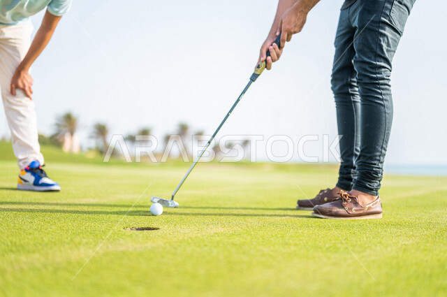 A close-up of two Saudi Arabian Gulf men, playing golf on large green areas, sports activities in Saudi Arabia, golf, summer Olympic sports, recreational activities, enjoying playing, identifying and shooting the target