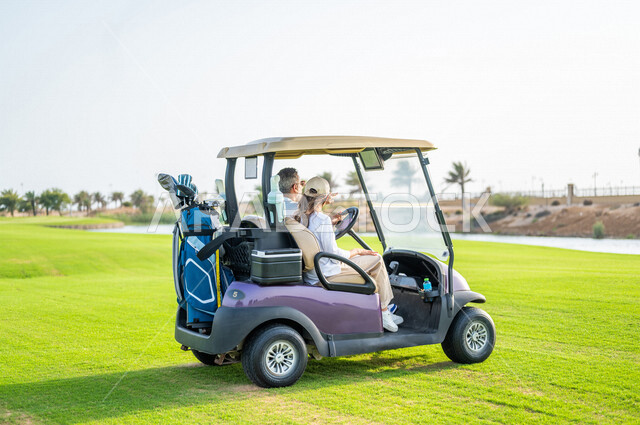 رجل وإمرأة عربيان خليجيان سعوديان داخل سيارة كهربائية مختصة بنقل الركاب، لعبة الغولف ( الجولف ) ، أنشطة رياضية بالسعودية، رياضات الألعاب الأولمبية الصيفية، أنشطة ترفيهية، ملعب الجولف، سيارة كهربائية، نادي الجولف، عربة الجولف