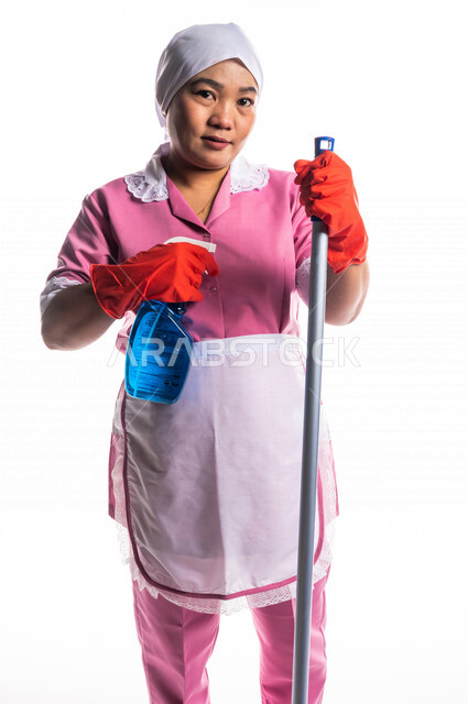 Portrait of a cleaning lady wearing gloves and an apron, carrying in ...