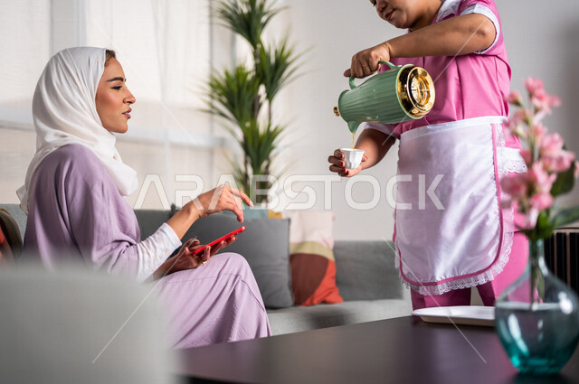 عاملة نظافة ترتدي المئزر ، تقوم بتقديم القهوة لسيدة المنزل ، إستقبال الضيوف ، حسن الضيافة والإستقبال ، المهام والأعمال المنزلية الروتينية ، مدبرة منزل ، خادمة منزلية أجنبية
