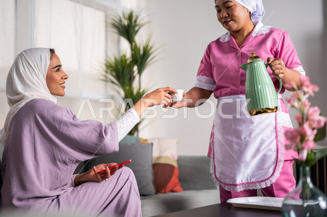 عاملة نظافة ترتدي المئزر ، تقوم بتقديم القهوة لسيدة المنزل ، إستقبال الضيوف ، حسن الضيافة والإستقبال ، المهام والأعمال المنزلية الروتينية ، مدبرة منزل ، خادمة منزلية أجنبية