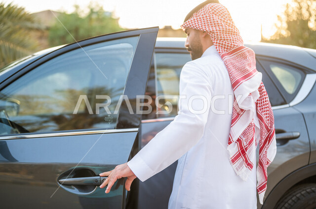 صورة من الخلف رجل عربي خليجي سعودي يفتح باب السيارة، الاستعداد لركوب السيارة، خدمة توصيل الركاب،  خدمات النقل الامنة، دروس تعليم قيادة السيارات، سيارة الاجرة