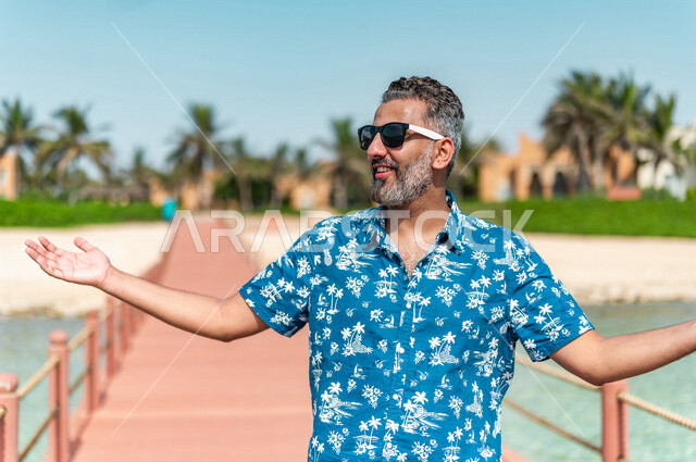صوره مقربه لرجل عربي سعودي خليجي في رحله صيفيه ممتعه, أنشطه ترفيهيه, جوله على شاطيء بحر جده, الفعاليات الصيفيه, الإسترخاء والإستجمام, الشعور بالسعاده, عطلات سياحيه, منتجع سياحي, ارتداء الملابس الكاجوال الصيفيه, السياحه في السعوديه