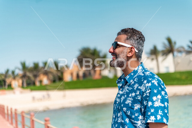 A close-up image of a Saudi Arabian Gulf man on a fun summer trip, recreational activities, a tour on the beach of the Jeddah sea, summer activities, relaxation and recreation, feeling happy, tourist holidays, tourist resort, summer casual wear, tourism i