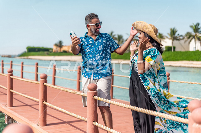 زوجان عربيان سعوديان خليجيان في رحله صيفيه ممتعه, عطلة متزوجين في شهر العسل, جوله على شاطيء بحر جده, وجهات سياحيه لشهر العسل, منتجع سياحي, أناقه صيفيه ملونه, السياحه في السعوديه