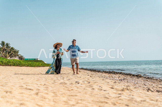 زوجان عربيان سعوديان خليجيان يستمتعان على شاطيء البحر, أجواء رومانسيه, وجهات سياحيه في شهر العسل، المشي على رمال البحر، سياحة وإستجمام، دردشة ومحادثات، أناقه شاطئيه ملونه, الإجازه الصيفيه, وجهات سياحيه في شهر العسل