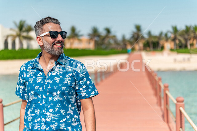 صوره مقربه لرجل عربي سعودي خليجي في رحله صيفيه ممتعه, عطله صيفيه, أنشطه ترفيهيه, جوله على شاطيء بحر جده, التنزه والترفيه, عطلات سياحيه, منتجع سياحي, ارتداء الملابس الصيفيه, السياحه في السعوديه