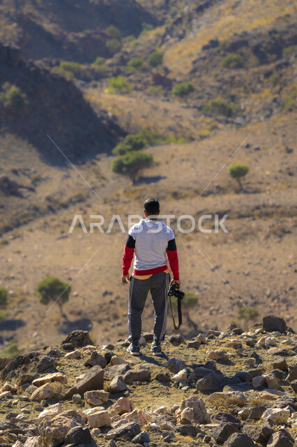 زاوية من الخلف لرجل يحمل بيده كاميرا ، فن وموهبة التصوير ، المناطق الصحراوية بالمملكة العربية السعودية ، صحاري السعودية