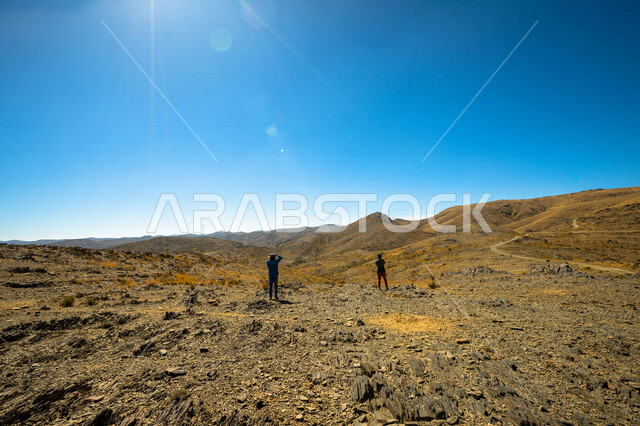 Angle from the back of tourists taking pictures in the desert areas, the art and talent of photography, the desert areas of Saudi Arabia, the deserts of Saudi Arabia