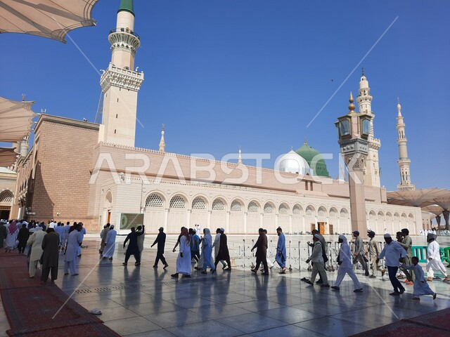 مجموعة من المصلين في ساحة المسجد النبوي الشريف في المدينة المنورة بالمملكة العربية السعودية، العبادة والتقرب الى الله، الحرم النبوي الشريف، أماكن إسلامية مقدسة، المظلات الإلكترونية، إسلاميات وعبادة، معالم دينية إسلامية