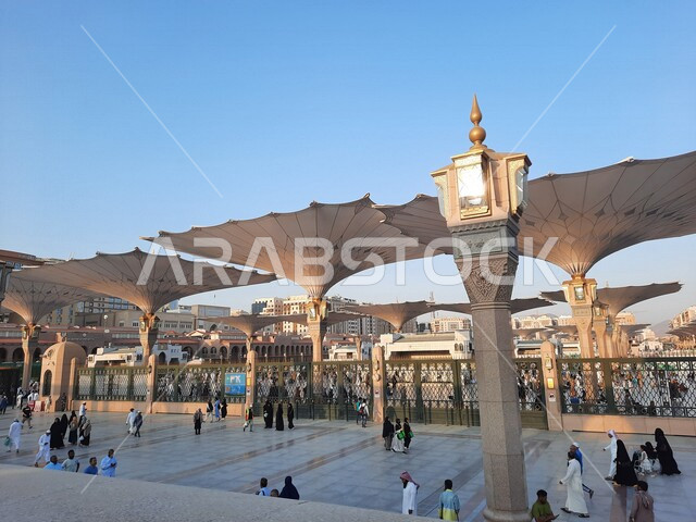 ساحة المسجد النبوي الشريف في المدينة المنورة بالمملكة العربية السعودية، العبادة والتقرب الى الله، الحرم النبوي الشريف، أماكن إسلامية مقدسة، تجمع المسلمون في المجمع الخارجي للمسجد النبوي في المدينة المنورة، المظلات الإلكترونية، معالم دينية إسلامية