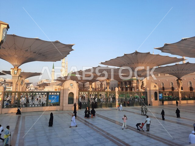 The square of the Prophet’s Mosque in Medina, Saudi Arabia, worship and getting closer to God, the Prophet’s Mosque, holy Islamic places, Muslims gathering in the outer complex of the Prophet’s Mosque in Medina, electronic umbrellas, Islamic religious lan