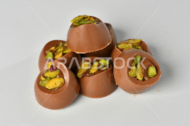 قالب قطع حلوى الشوكولاتة ، صناعة وإعداد حلوى الشوكولاته , مجموعة من حبات الشوكولاتة , حلويات مناسبات واستقبال , حلوى العيد , ترافل بالشوكولاتة , زبدة البندق مع الشوكولاتة، حلويات وسكريات , خلفية بيضاء .